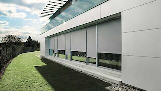 weißes Gebäude mit Zip-Screens verschiedener Breiten